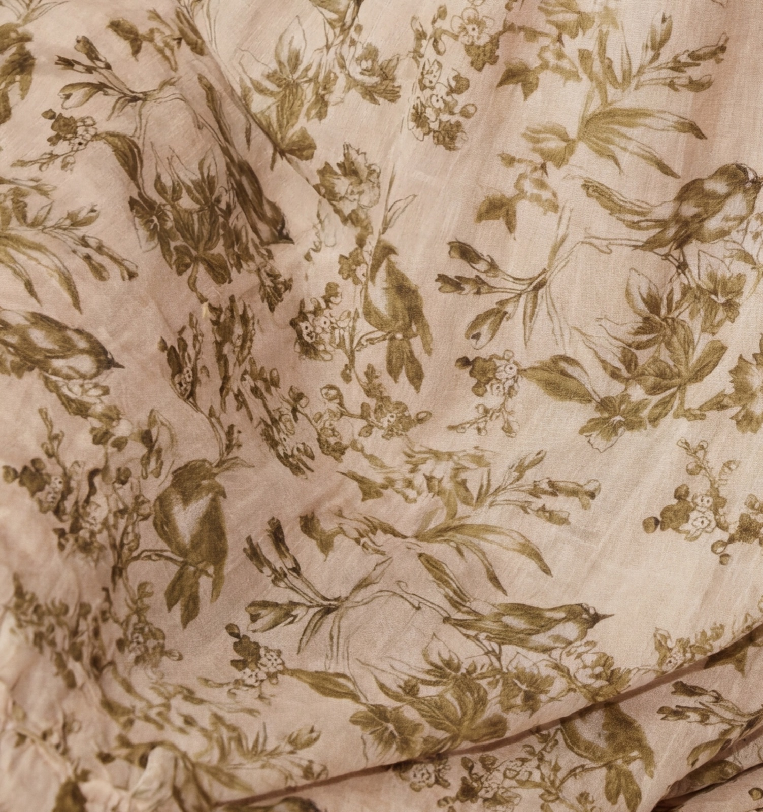 Close-up of double-layered muslin cotton in the olive bird print